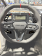 Steering wheel and dashboard of a Can-Am vehicle with Heretic branding.